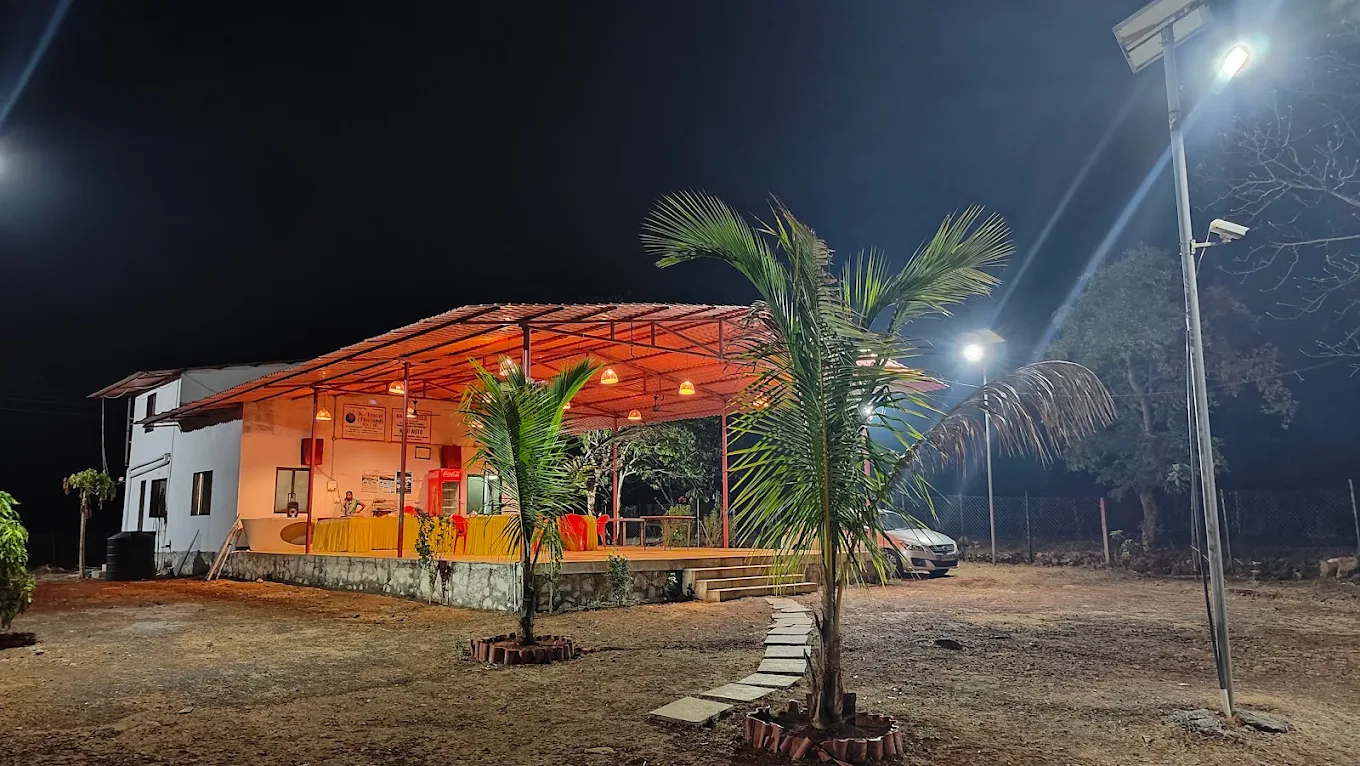 The open-air Punjabi dhaba lit up at night with palm trees